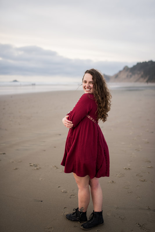 Southern Oregon Coast photographer wears a red dress on the beach during blue hour in Brookings, Oregon.