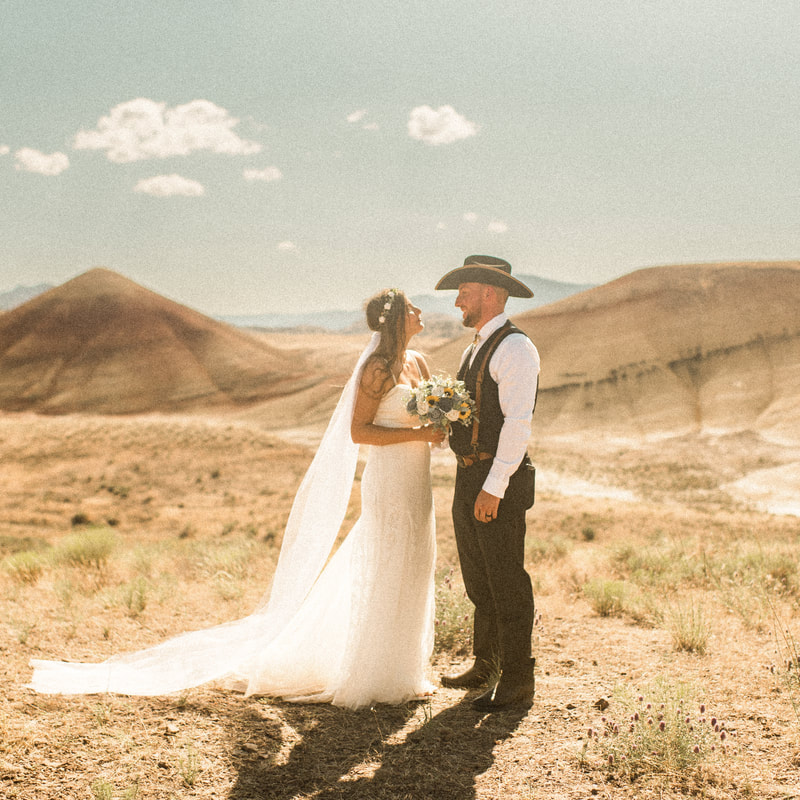 vibrant image of bride and groom standing in the painted hills for their oregon adventure elopement