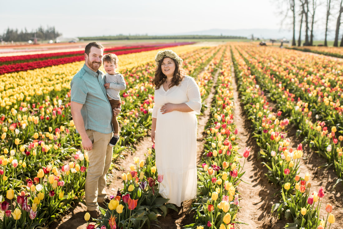 family of three pose in tulip fields